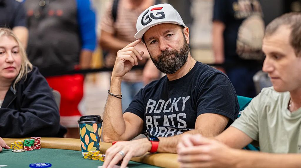 Professional poker player Daniel Negreanu sitting at a poker table during the World Series of Poker, looking focused and wearing a GGPoker hat